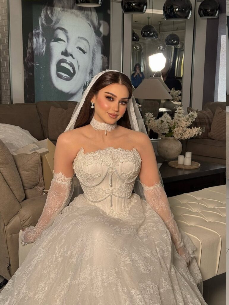 Woman in a white lace wedding dress with a corset bodice and bridal veil.