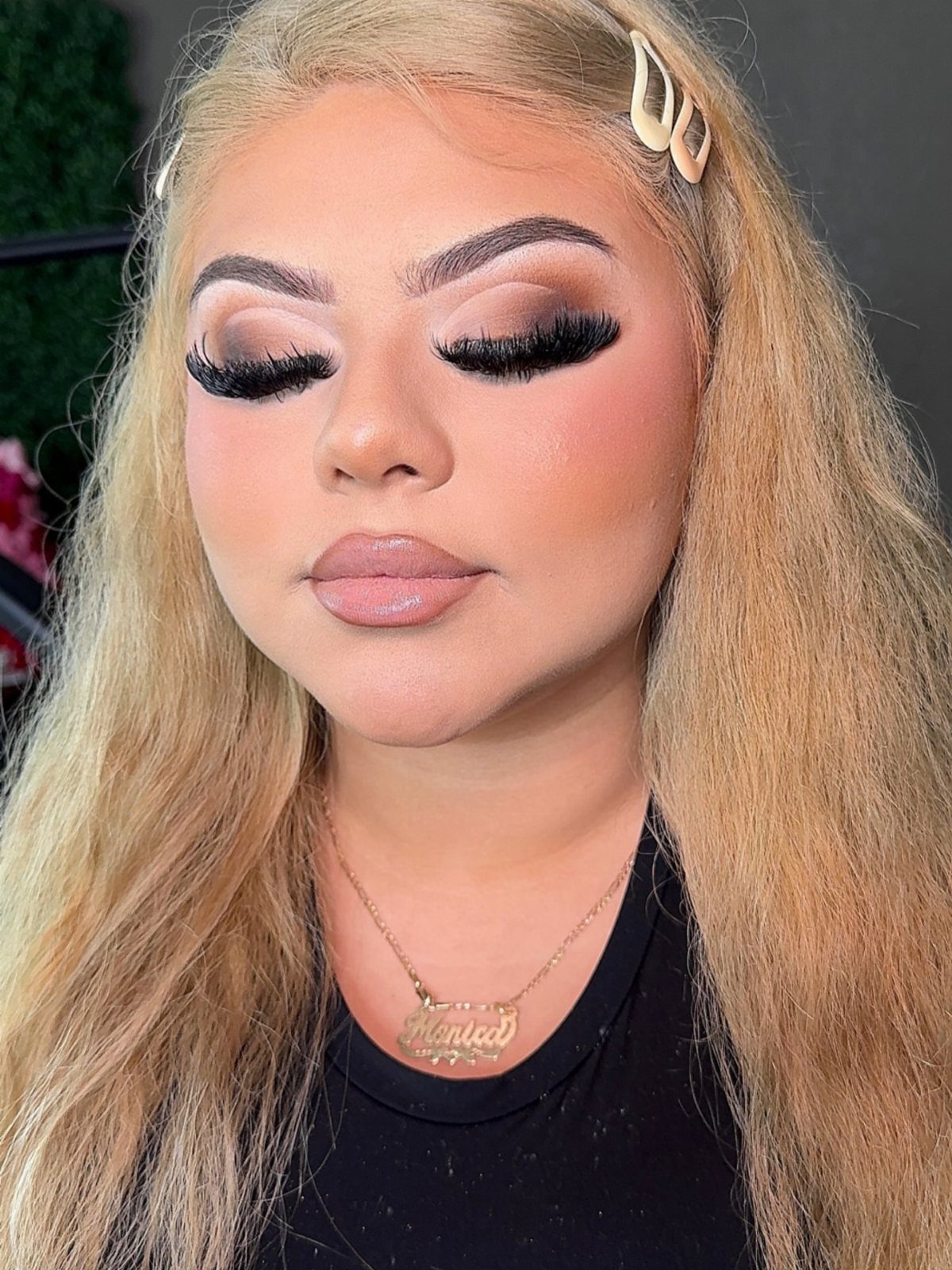 Woman with blonde hair wearing bold full glam makeup and dramatic false eyelashes