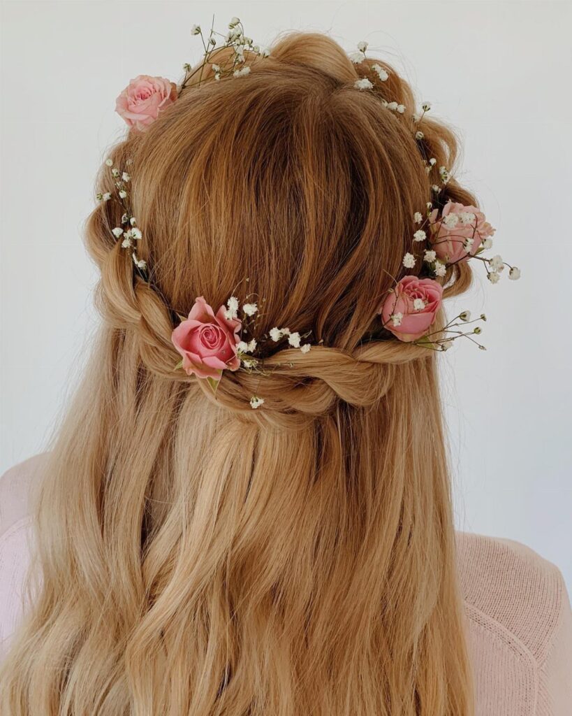 Blonde hair in a braided half-up style with a pink rose floral crown.