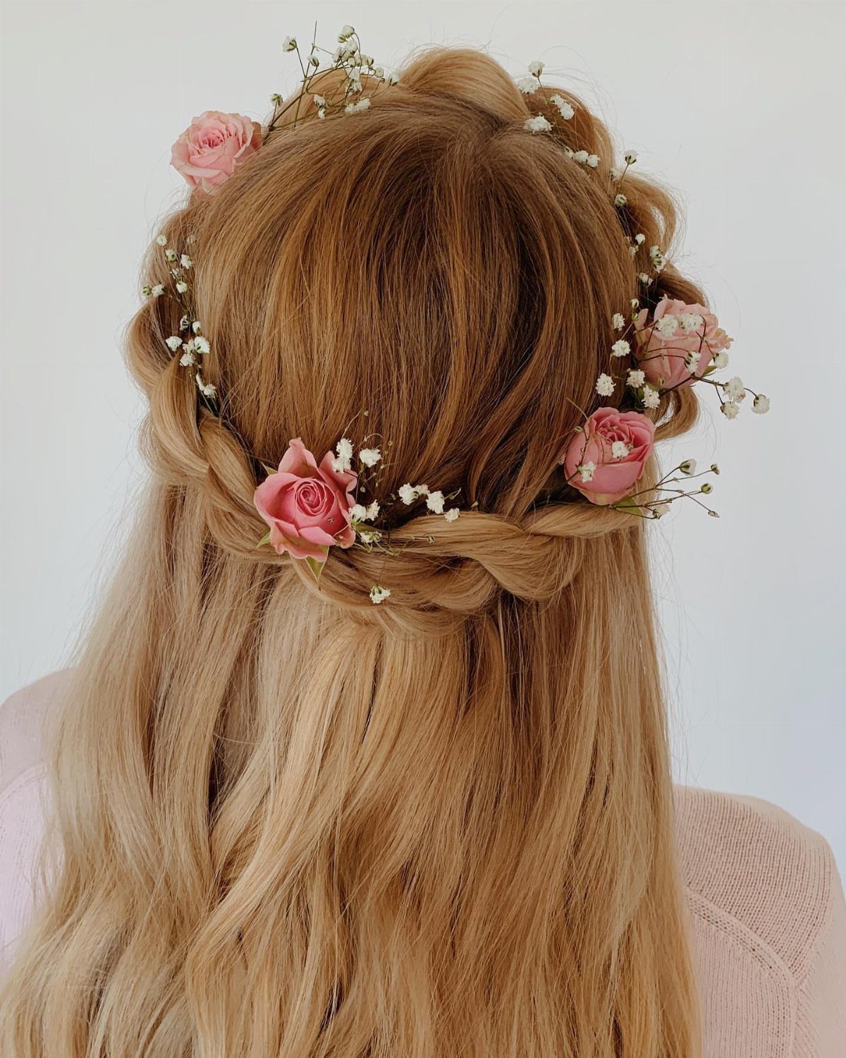 Blonde hair in a braided half-up style with a pink rose floral crown.