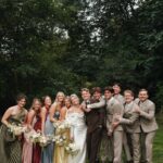 Wedding party with an uneven number of bridesmaids and groomsmen posing outdoors.