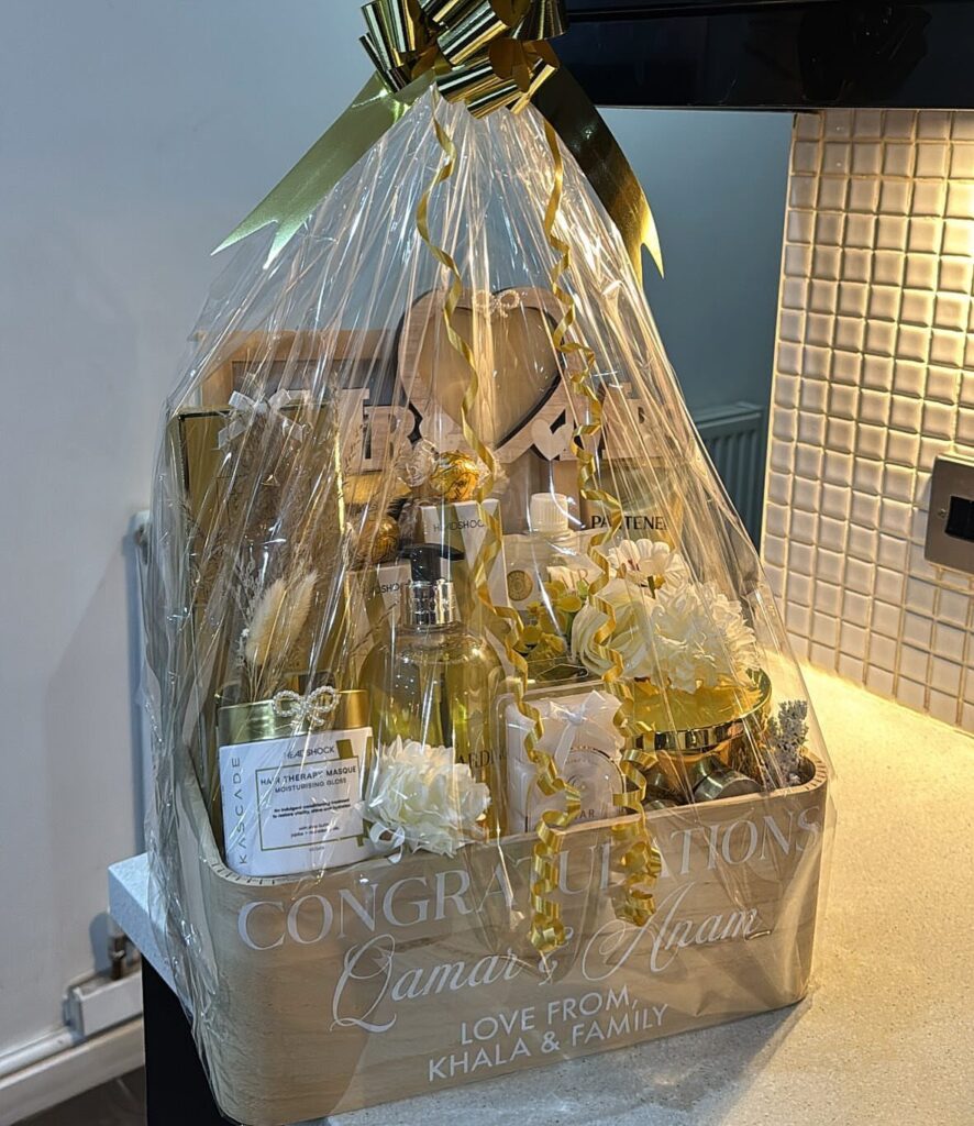 Gift hamper wrapped in cellophane with a gold bow and congratulatory wedding message.
